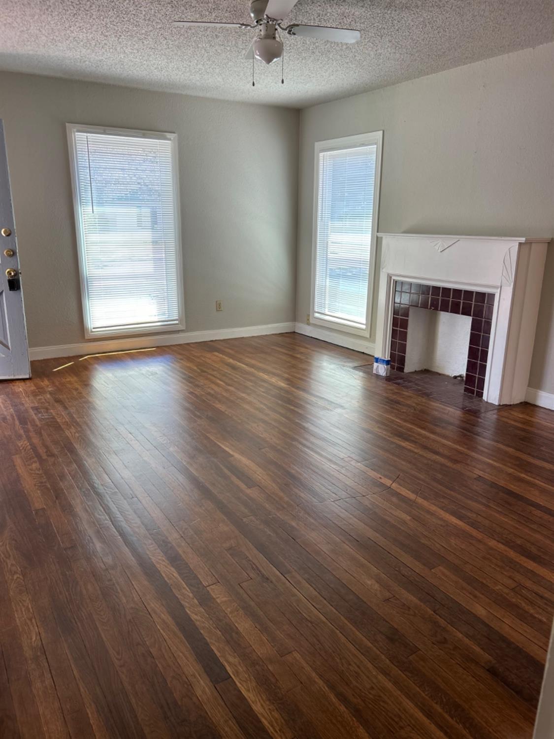 2818 27th Street Lubbock, TX 79410 - Photo 6 of 7 an empty room with wooden floor cabinet and windows