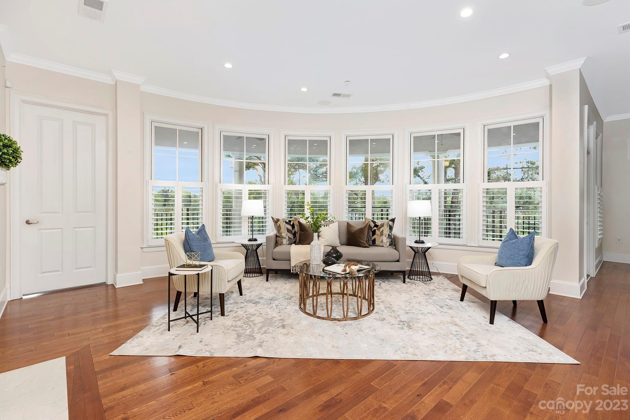 a living room with furniture and floor to ceiling windows