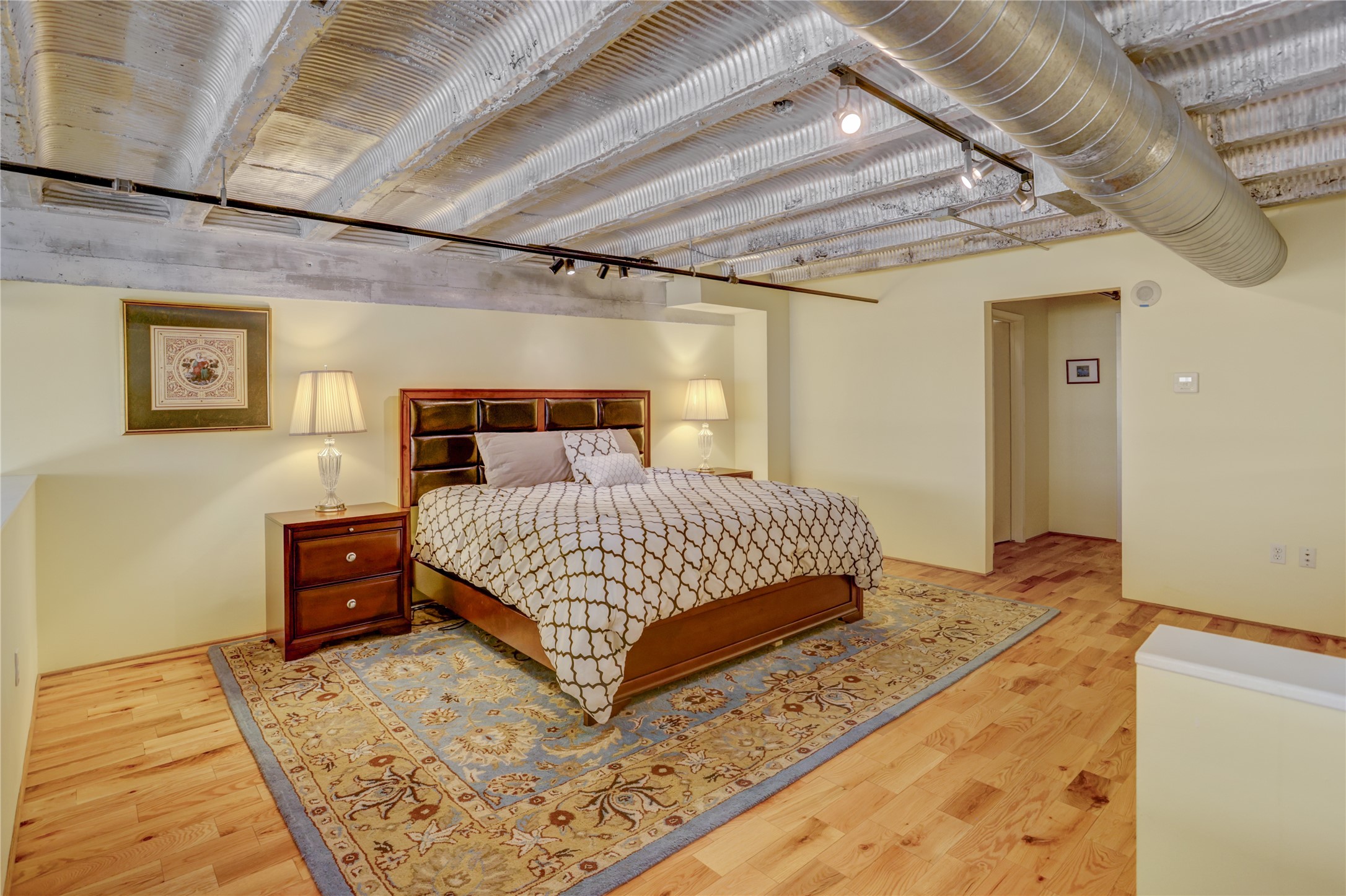 917 Main Street, Unit 1107 Houston, TX 77002 - Photo 12 of 33 a bedroom with a large bed and a wooden floor