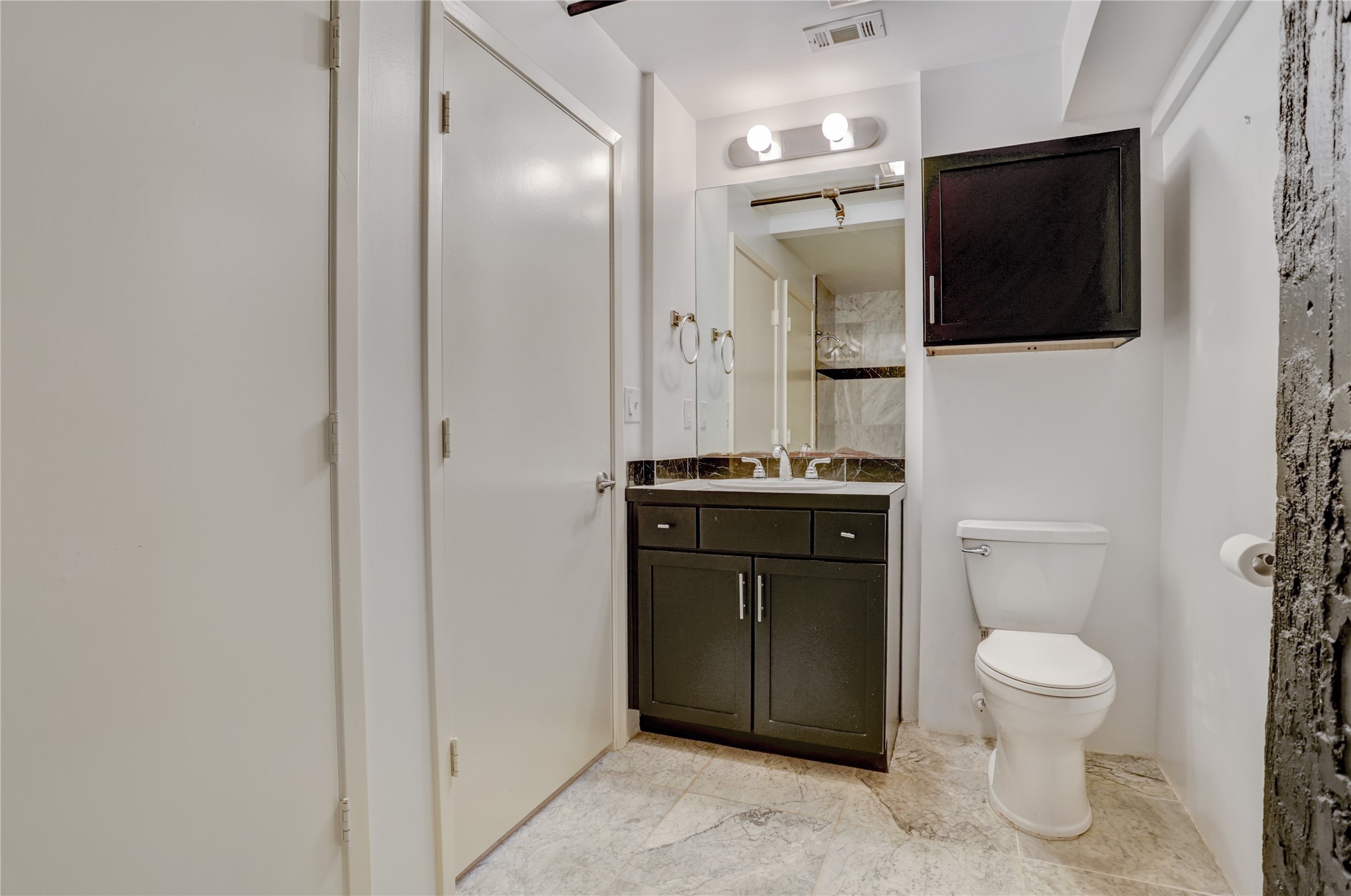 917 Main Street, Unit 1107 Houston, TX 77002 - Photo 10 of 33 a bathroom with a toilet a sink and mirror