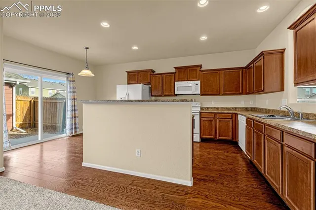 a kitchen with stainless steel appliances wooden cabinets a refrigerator and a stove top oven