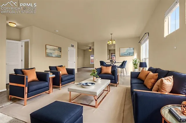 a living room with furniture fireplace and a large window