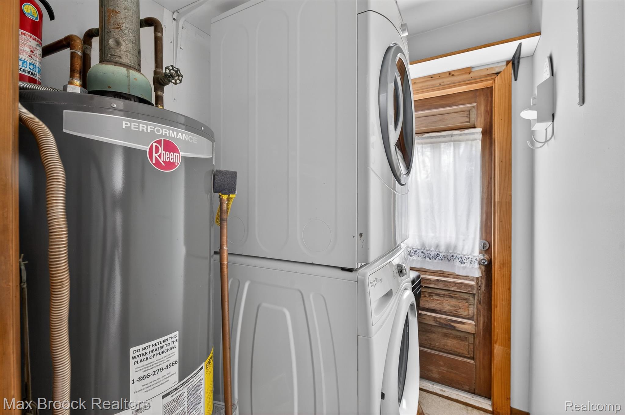 9024 Mandon Road White Lake, MI 48386 - Photo 27 of 39 Laundry room with gas water heater and stacked washer and clothes dryer