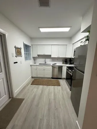 a kitchen with wooden floors and appliances