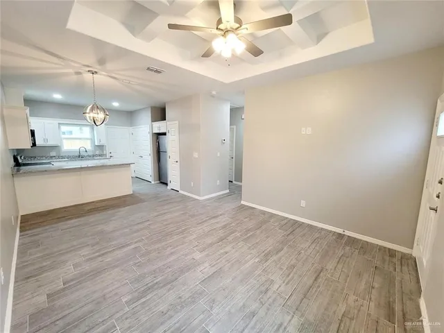 a view of a kitchen with a sink dishwasher a refrigerator with wooden floor