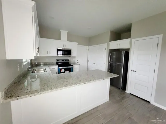 a kitchen with granite countertop a refrigerator and a sink
