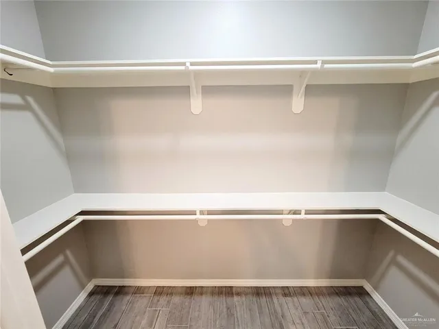 a view of walk in closet with empty racks