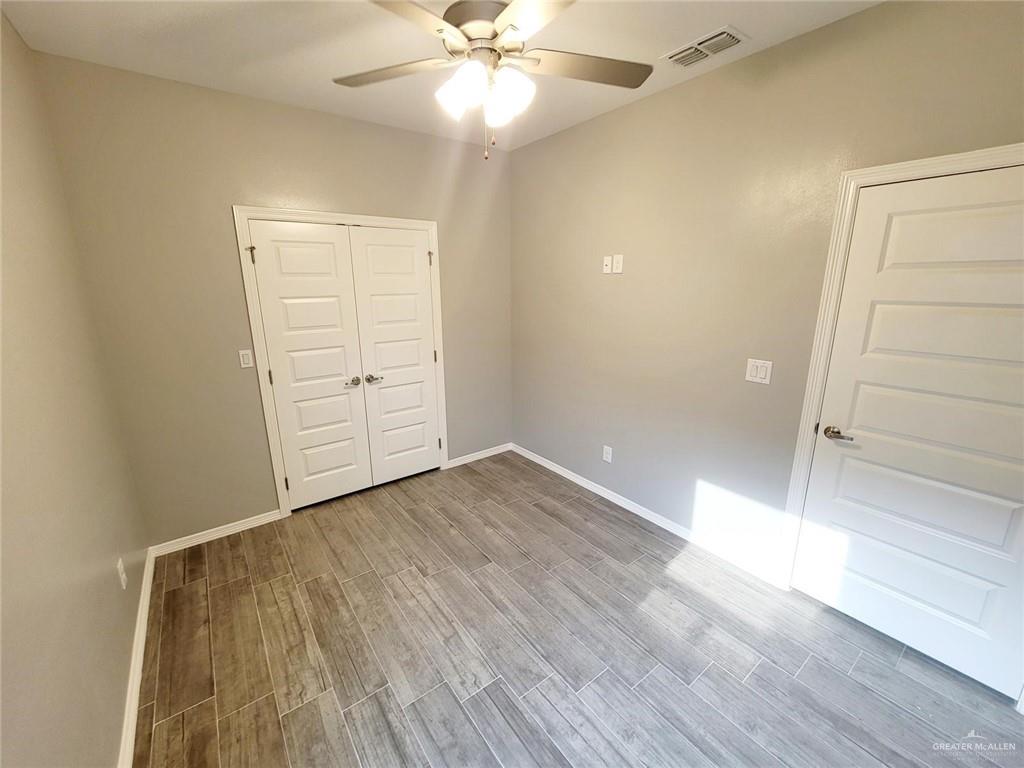 1805 Davenport Street, Unit 1 Weslaco, TX 78596 - Photo 15 of 20 an empty room with wooden floor closet and windows