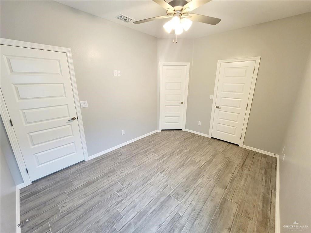 1805 Davenport Street, Unit 1 Weslaco, TX 78596 - Photo 16 of 20 an empty room with wooden floor closet fan and windows