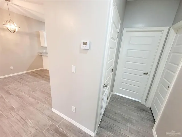 an empty room with wooden floor closet fan and windows