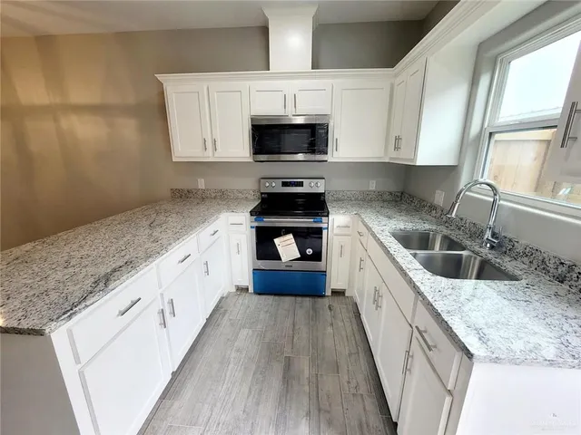a large kitchen with a stove and a sink