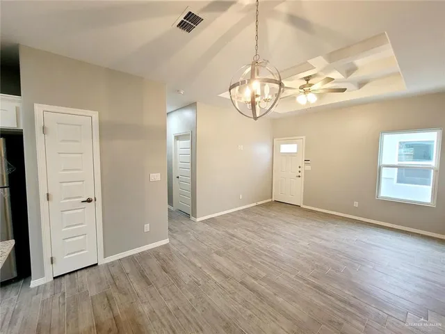 an empty room with wooden floor and window