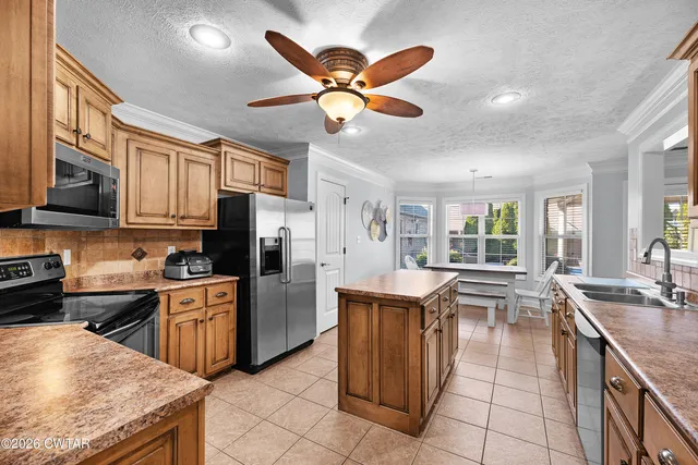 a kitchen with stainless steel appliances granite countertop a sink dishwasher stove top oven and cabinets