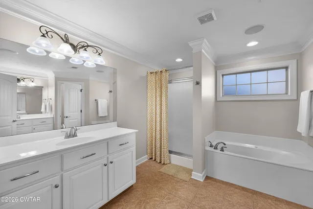 a bathroom with a double vanity sink mirror and bathtub