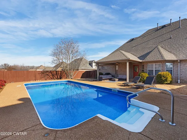 a view of house with swimming pool yard and outdoor seating