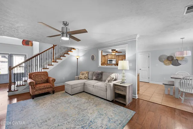 a living room with furniture and a wooden floor