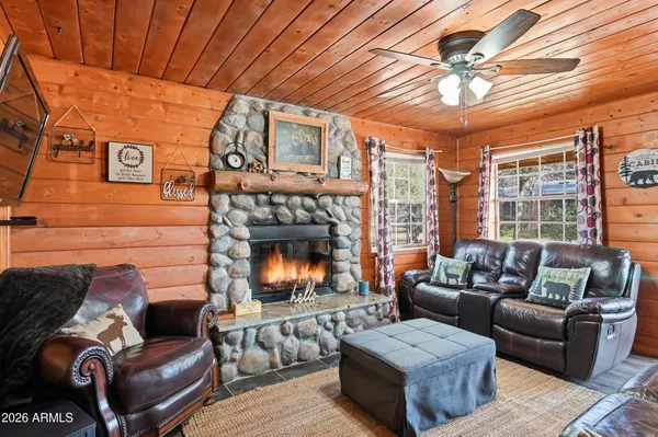 a living room with furniture a fireplace and a ceiling fan