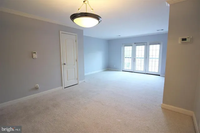 a view of a big room with windows and chandelier fan