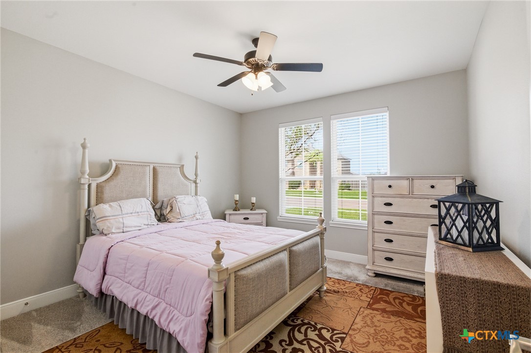 113 Terra Vista Ranch Road Victoria, TX 77904 - Photo 33 of 47 a bedroom with a bed and a chandelier