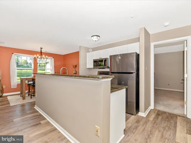 a large kitchen with granite countertop a large counter top space and stainless steel appliances