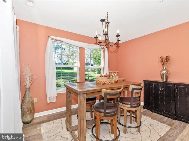 a dining room with furniture a chandelier and wooden floor