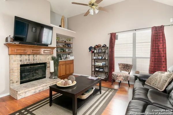 a living room with furniture a flat screen tv and a fireplace