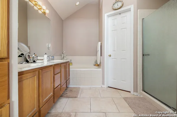 a spacious bathroom with a bathtub sink and mirror