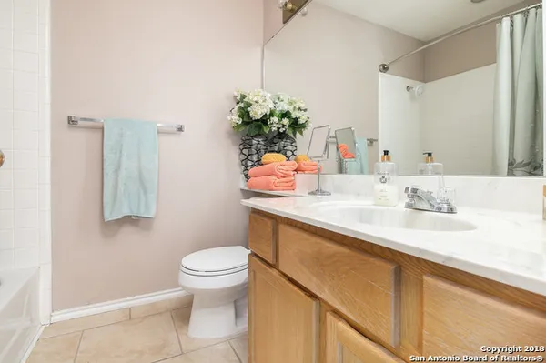 a bathroom with a granite countertop sink a toilet and a mirror