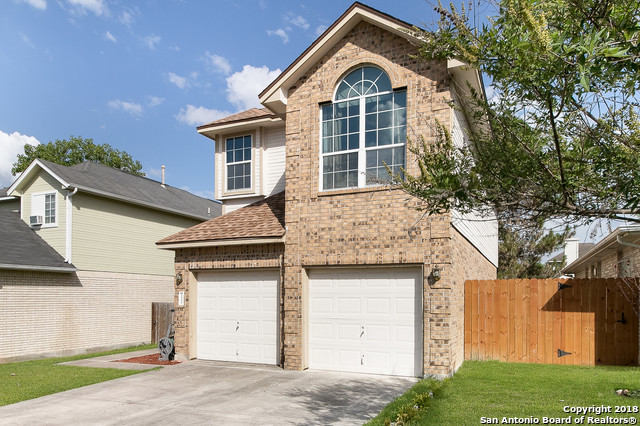 5858 Spring Square San Antonio, TX 78247 - Photo 2 of 21 a front view of a house with a yard and garage