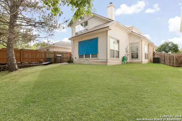 a large house with a big yard and large trees