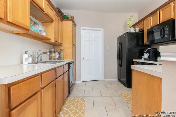 a kitchen with stainless steel appliances a sink a refrigerator and cabinets