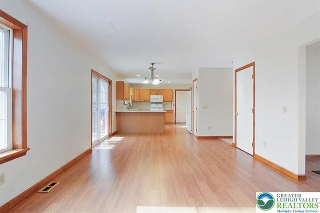 a view of a kitchen with wooden floor and a window