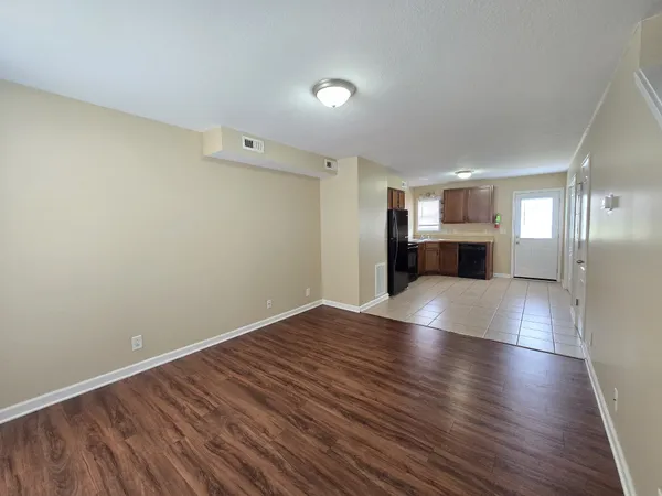 a view of empty room with wooden floor