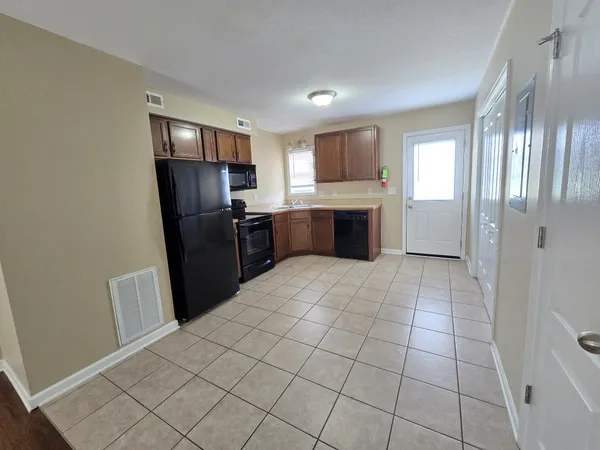 a view of a kitchen with refrigerator and window