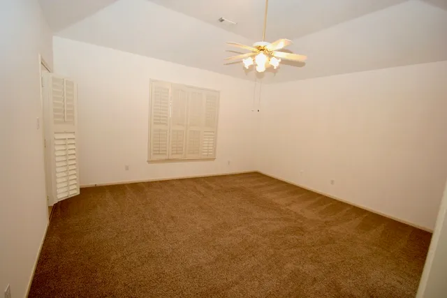 en empty room with windows and chandelier