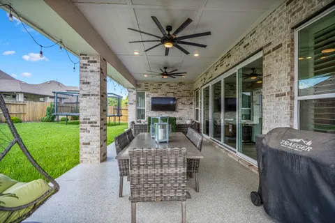 a view of a patio with couches chairs and a floor to ceiling window