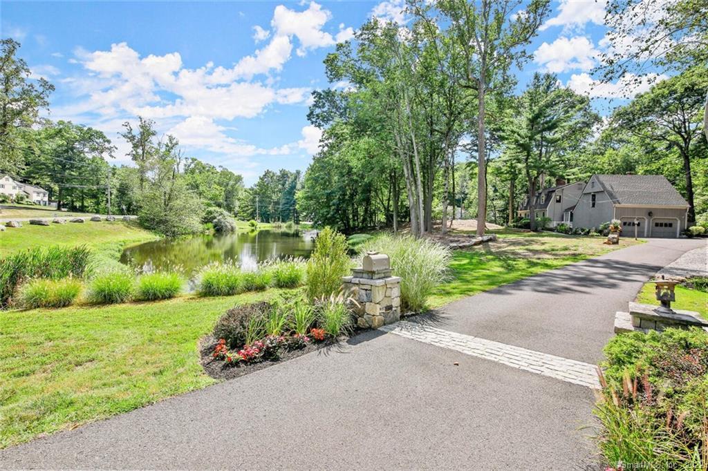 74 Indian Cave Road Ridgefield, CT 06877 - Photo 1 of 1 a view of a garden with a lake