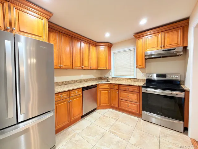 a kitchen with stainless steel appliances granite countertop a refrigerator sink and stove