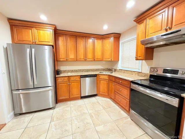 a kitchen with stainless steel appliances granite countertop a refrigerator stove top oven and sink