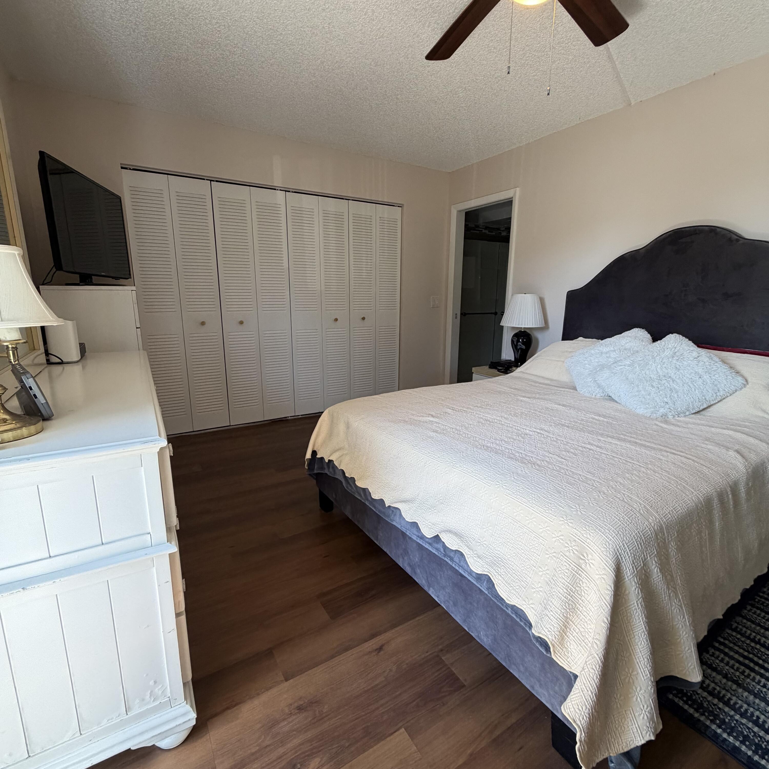 728 Normandy Lane, Unit P Delray Beach, FL 33484 - Photo 5 of 12 a bedroom with a bed and a flat tv screen on dresser