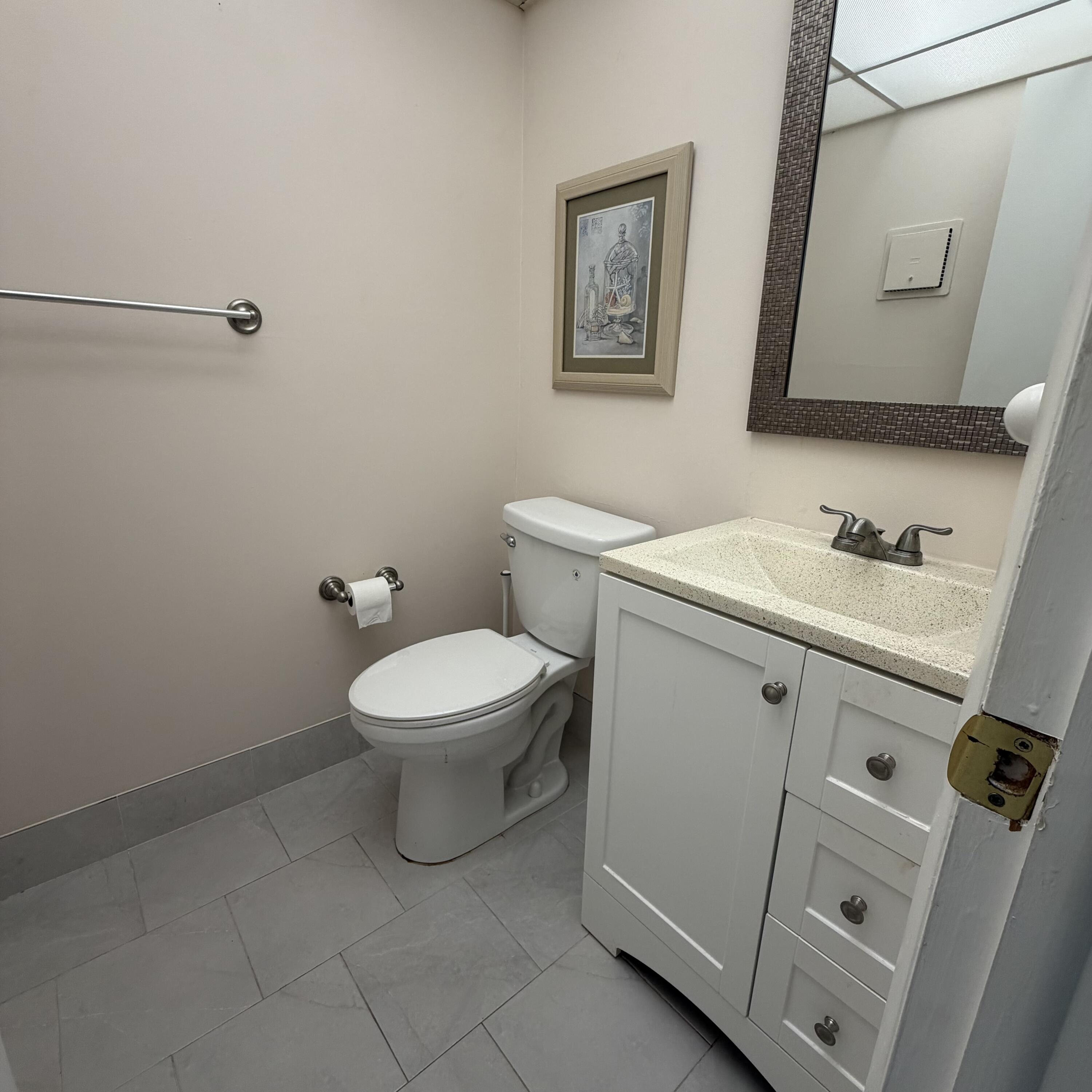 728 Normandy Lane, Unit P Delray Beach, FL 33484 - Photo 6 of 12 a bathroom with a toilet sink and mirror