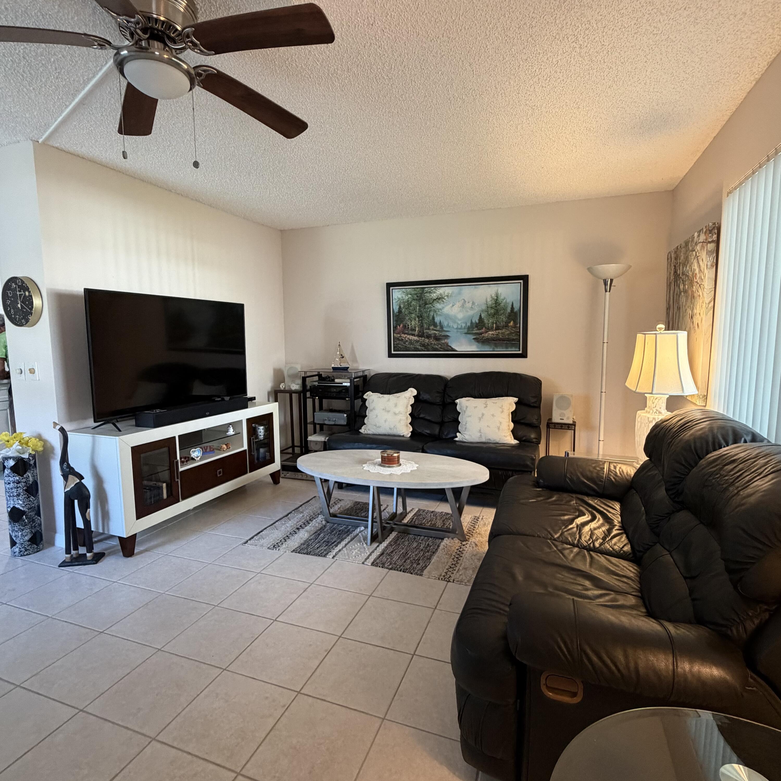728 Normandy Lane, Unit P Delray Beach, FL 33484 - Photo 8 of 12 a living room with furniture and a flat screen tv