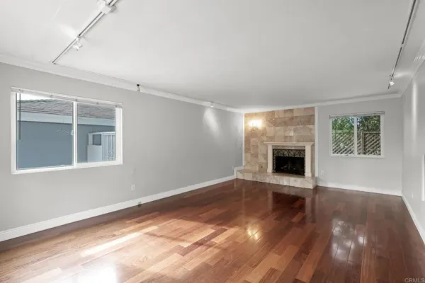 a view of empty room with wooden floor and fireplace