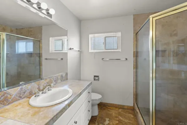 a bathroom with a sink a toilet and shower