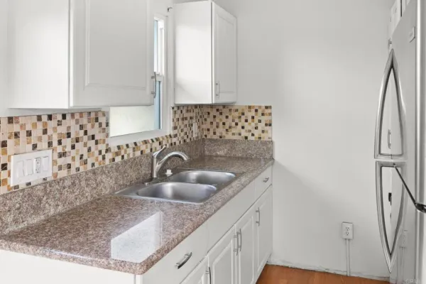 a kitchen with a refrigerator sink and cabinets