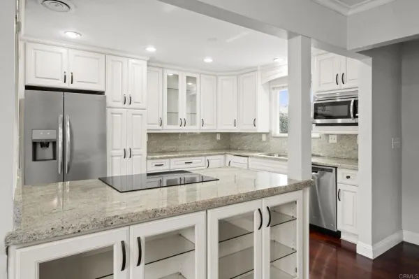 a kitchen with stainless steel appliances granite countertop a refrigerator and a sink