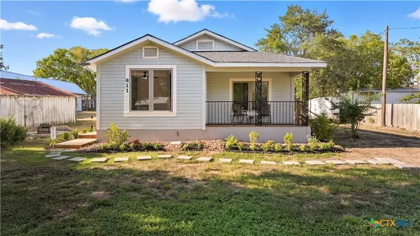 a front view of a house with a garden and yard