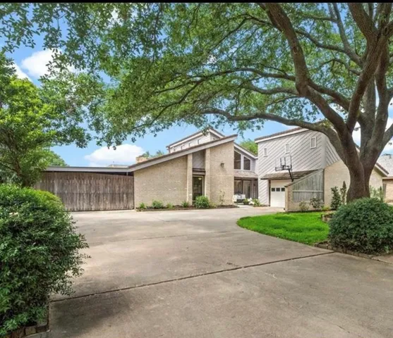 a front view of a house with a yard and trees