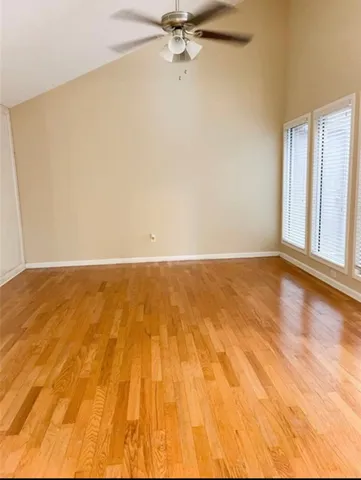 a view of a room with wooden floor and a ceiling fan