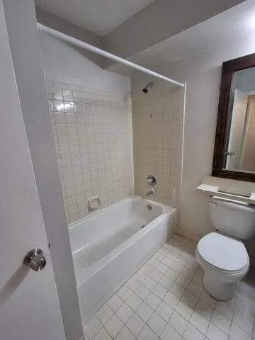 a bathroom with a sink a toilet a tub and shower
